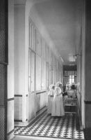 L'Institut Pasteur : hôpital Pasteur, couloir du pavillon Roux avec Soeur Godrick au 1er plan passant donner les soins vers 1910.