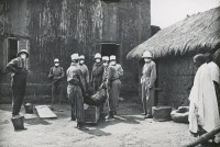 Mise en bière d'un cadavre pesteux par une équipe d'hygiène à Madagascar vers 1935
