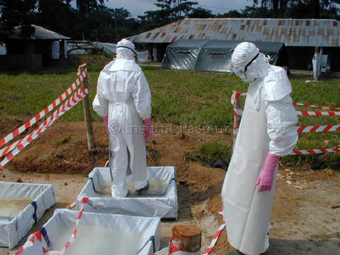 Epidémie à virus Ebola au Gabon en 2001. Personnel soignant se rendant au pavillon d'isolement